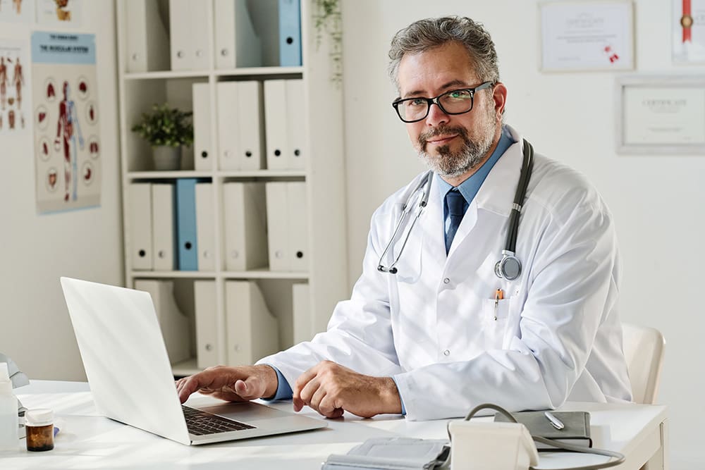 Doctor at his laptop reading about medical website design