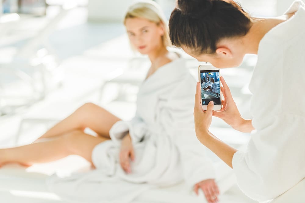 Two women at a spa taking a picture for social media using medspa hashtags