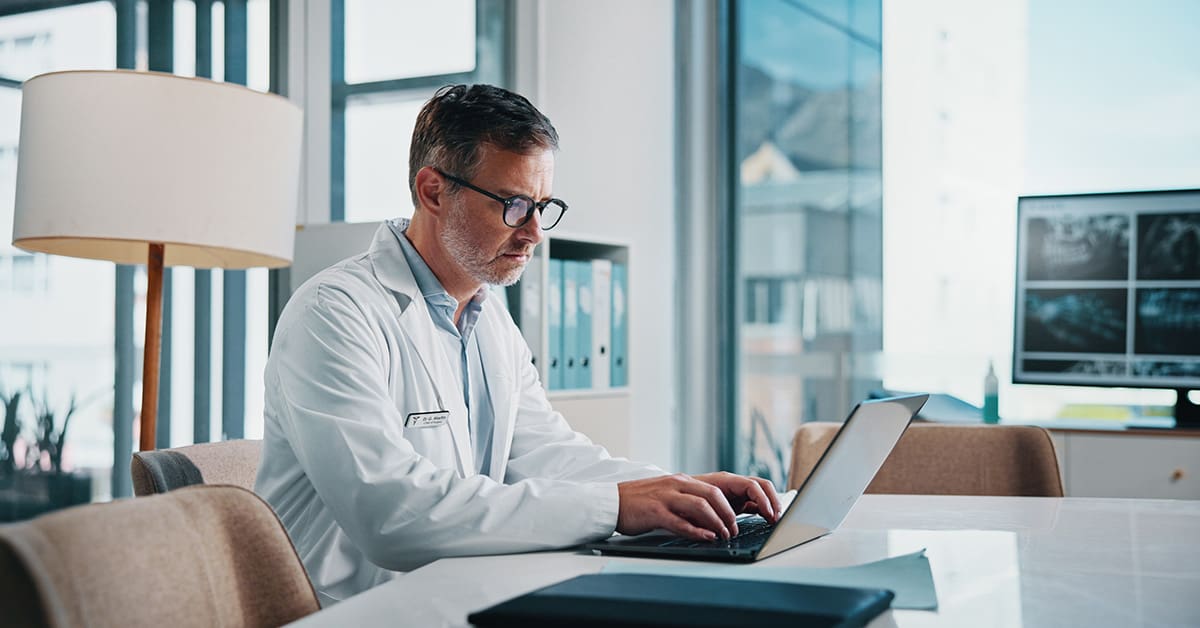 Doctor on a laptop learning how to create a healthcare website design that patients love