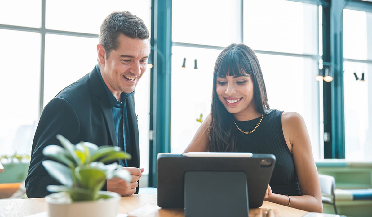 Two professionals at a tablet discussing a digital PR strategy